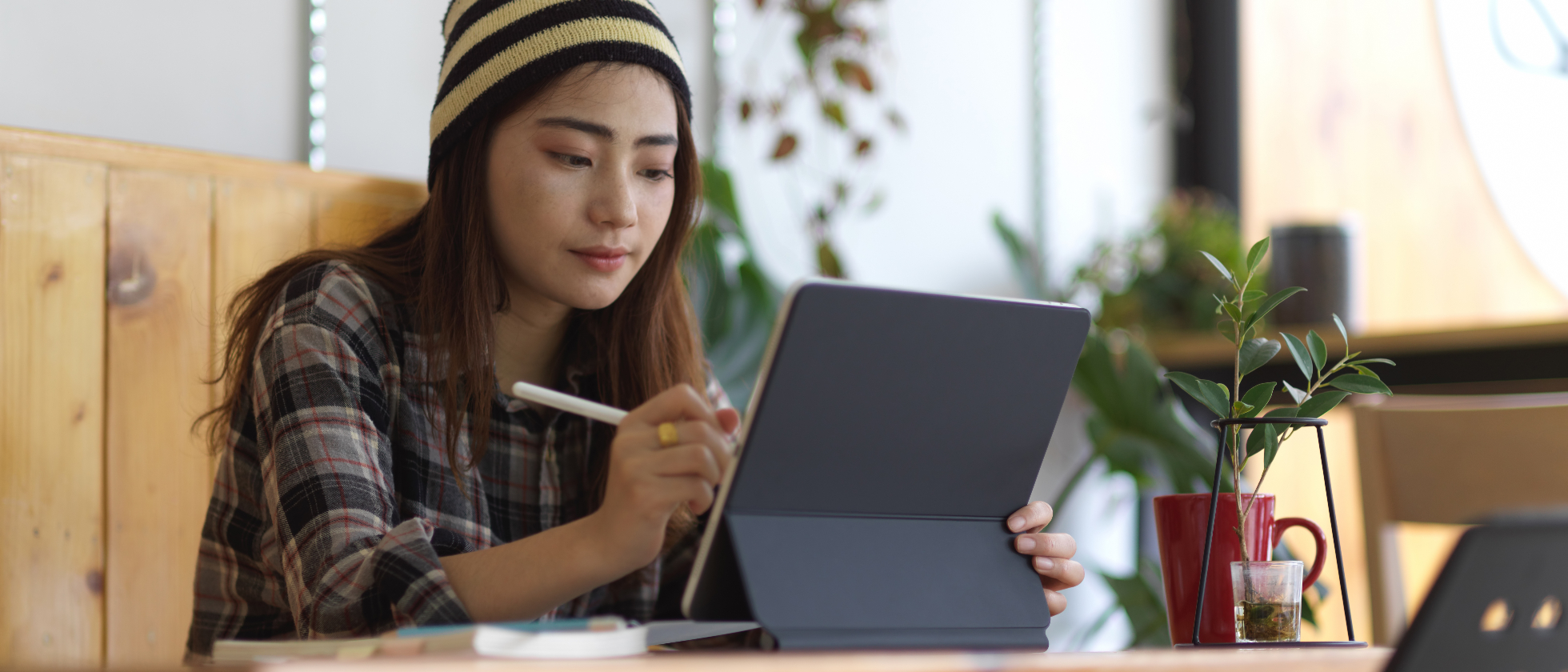 teenage girl doing homework on a digital tablet as an example of the struggle with ergonomics and posture