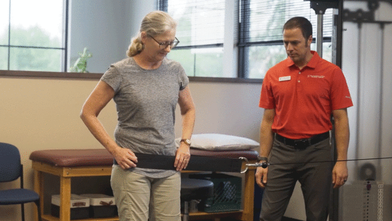PT Brian Weiderman assists a patient with exercise during physical therapy