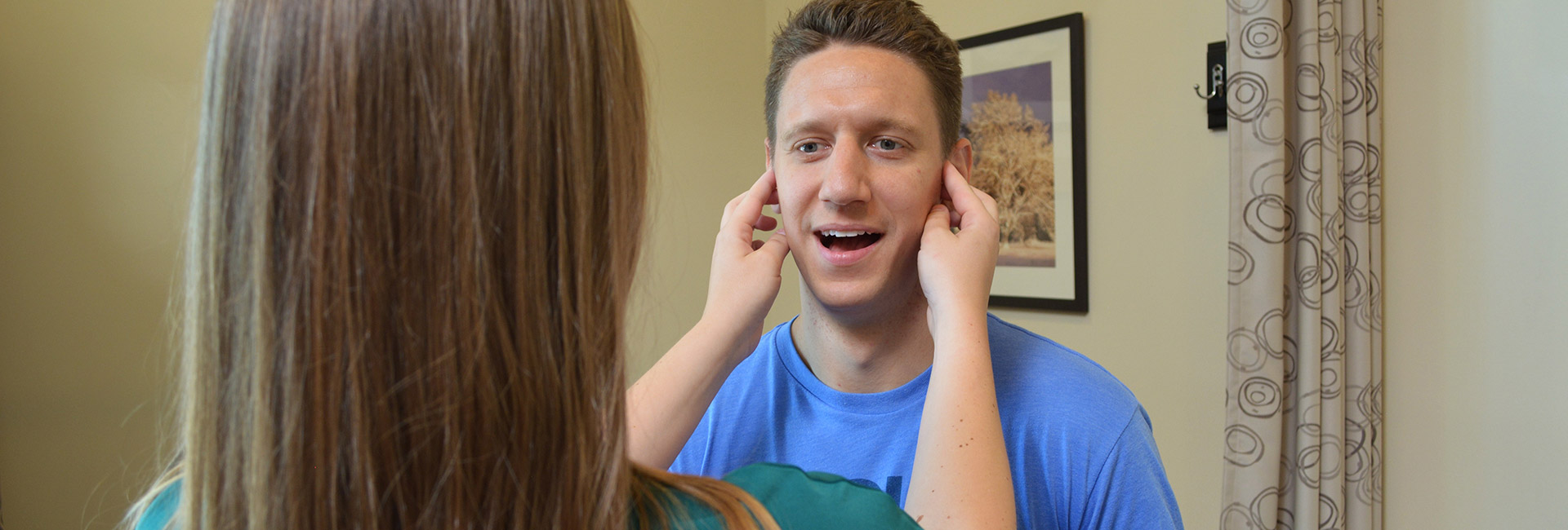 A physical therapist specializing in myofunctional therapy works on a patient's jaw
