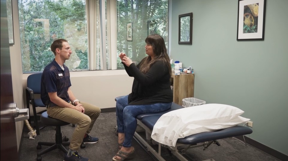 physical therapist takes time to listen to a patient explain their pain and identify goals