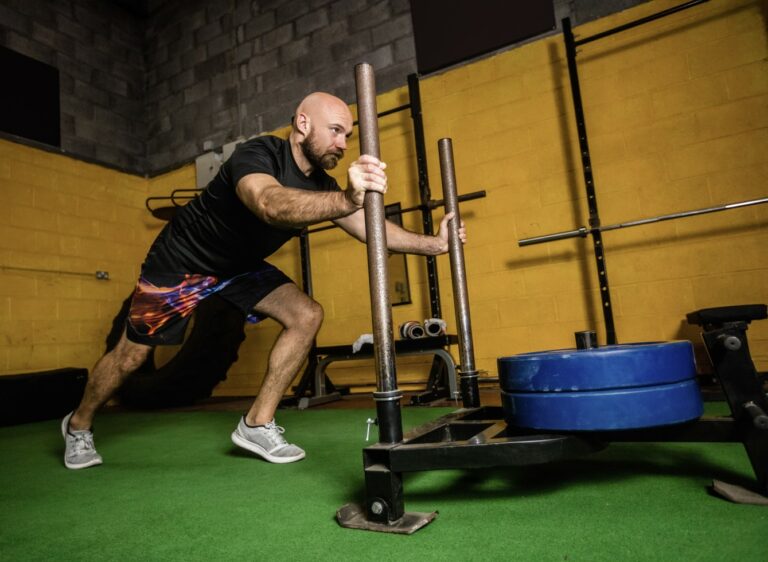 A CrossFit athlete pushes a sled in training