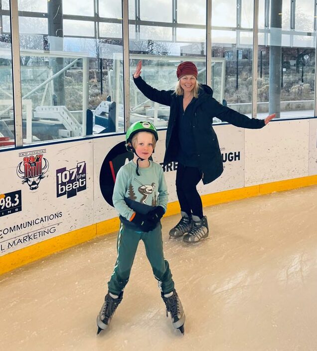 A woman and her son have fun ice skating together.
