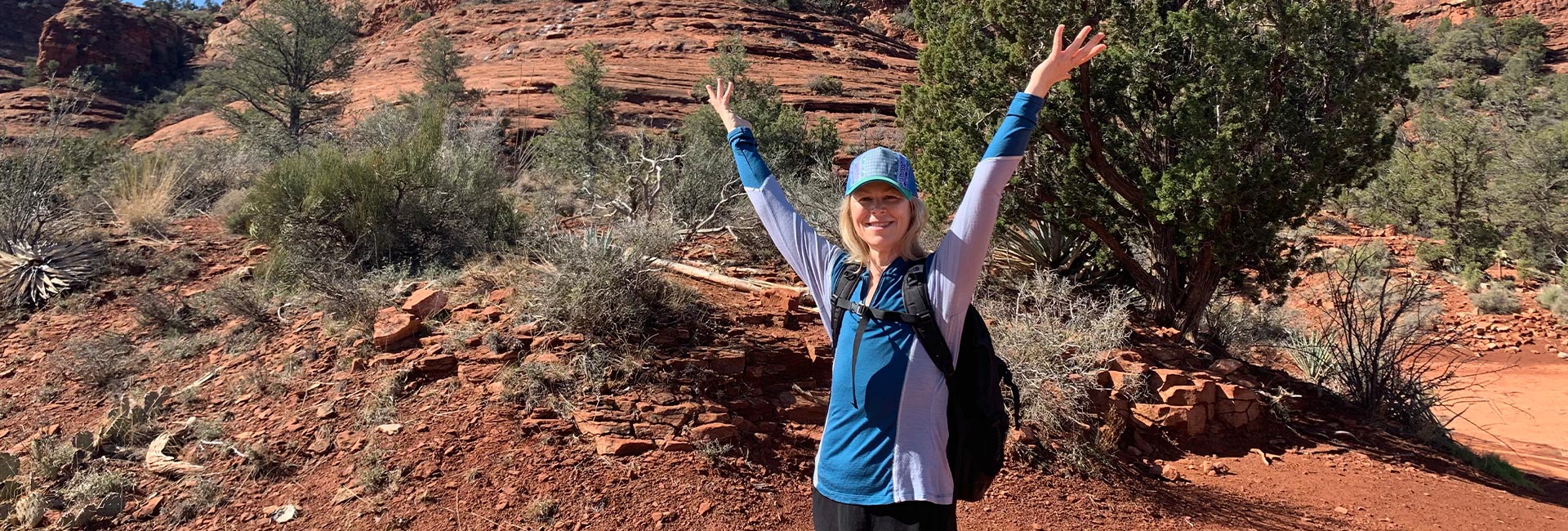A woman celebrates a hike at Red Rocks in Sedona, a milestone in her recovery from preventative bilateral mastectomy surgery