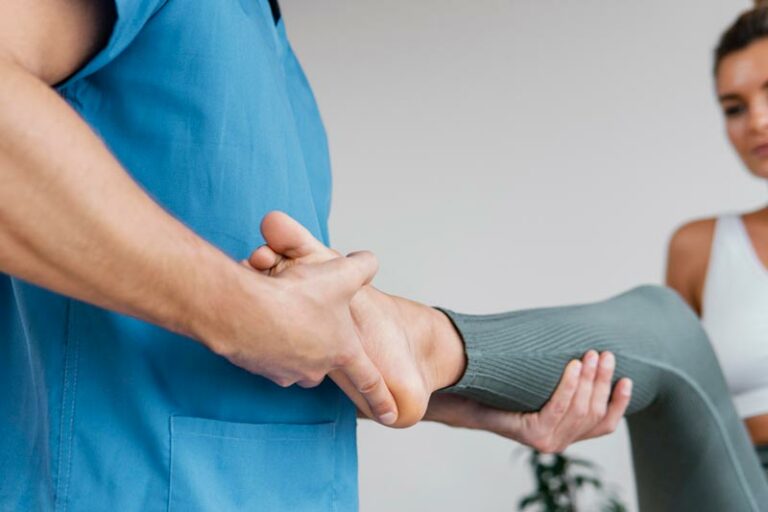physical therapist works with a patient on lower limb pain and injury to foot, ankle, lower leg