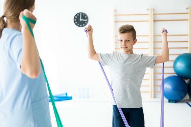 a boy works with resistance bands during physical therapy