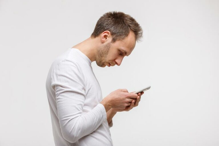 a man in extremely bad posture bent over his cell phone