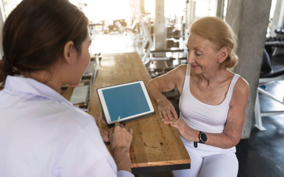 A doctor/PT helps a patient understand how to manage their condition - patient education