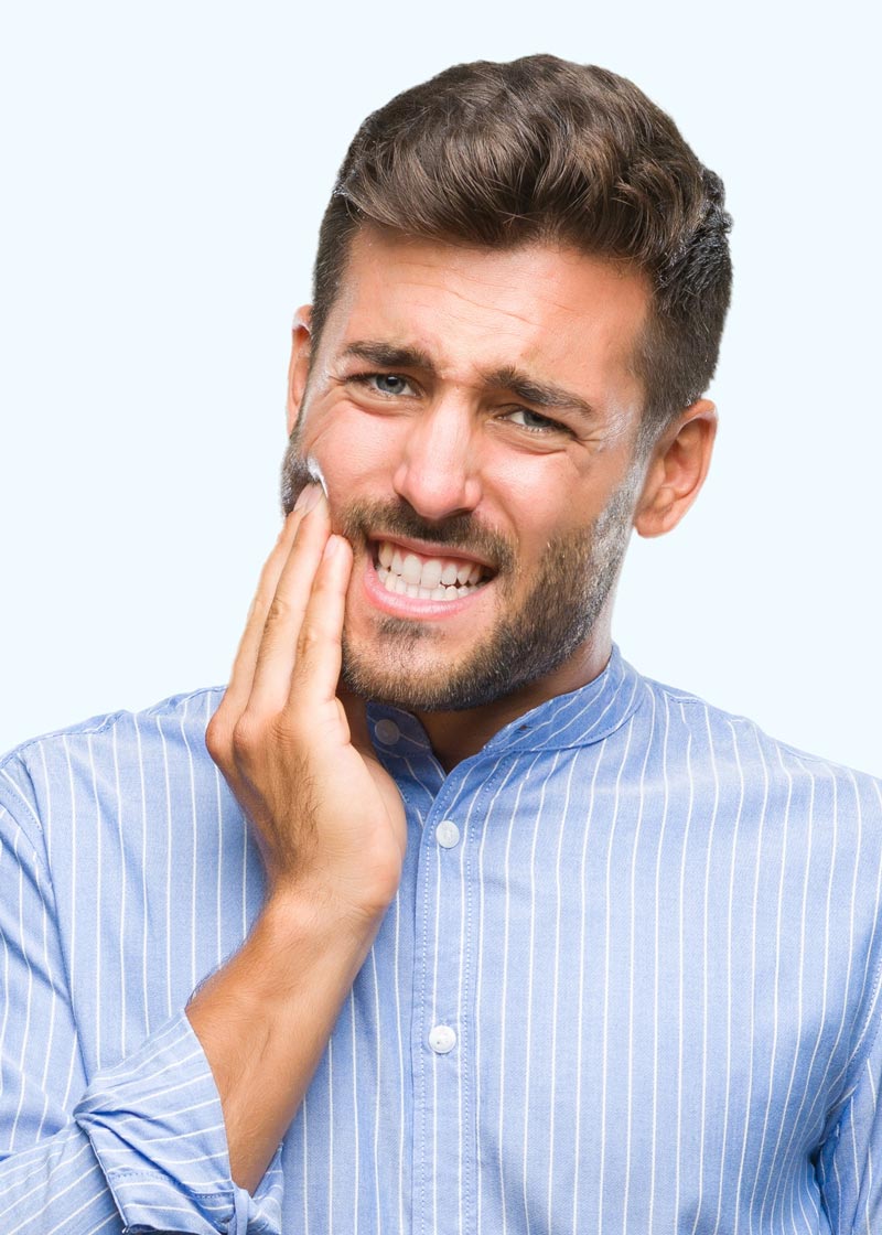 a man holds his jaw illustrating that he has tooth pain maybe related to TMD/TMJ