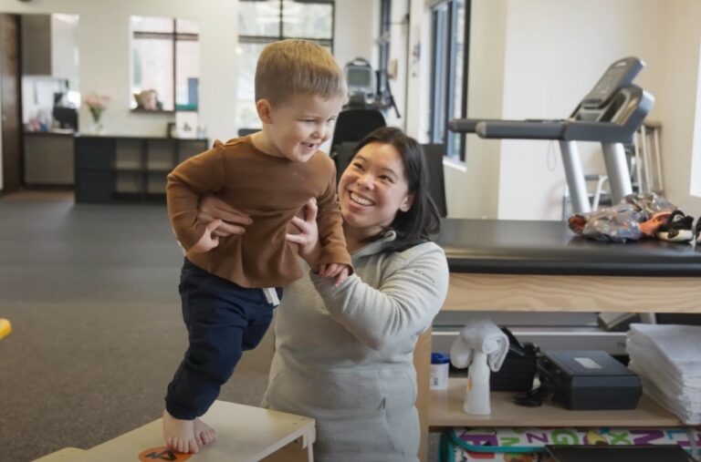 A physical therapist works with a pediatric patient
