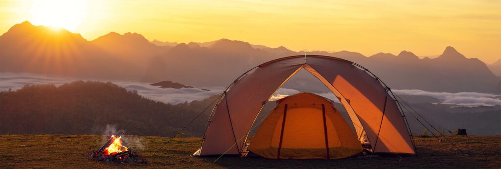 a camping scene at sunrise or sunset