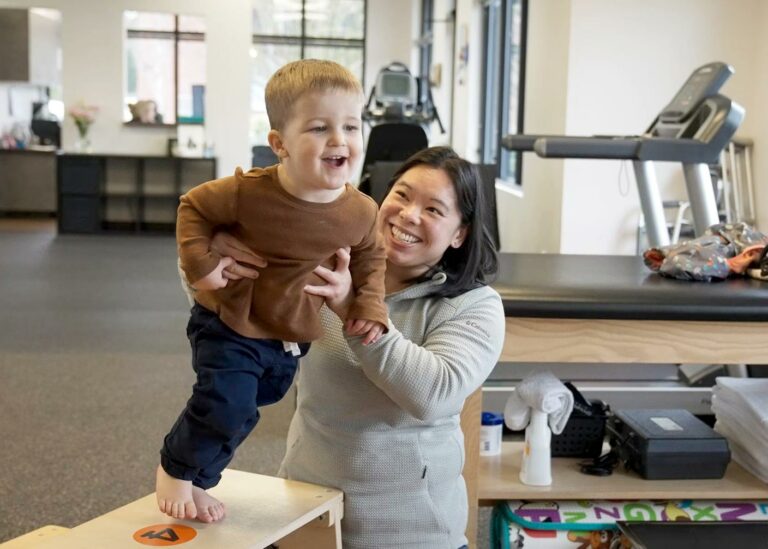 pediatric physical therapist works with a young patient utilizing an obstacle course for fun